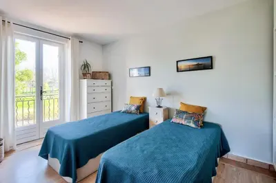 a bedroom with two beds and a window at Les Mas et Villas de Pont Royal en Provence - maeva Home - Villa duplex moderne et vintage 3 pièces 6 personnes climatisée - Prestige - super Home MAE-4211 in Mallemort