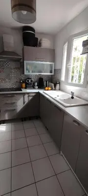a white kitchen with a sink and a window at Chez Kristina in Entraigues-sur-la-Sorgue