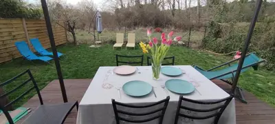 a table with a vase of flowers on a deck at Chez Kristina in Entraigues-sur-la-Sorgue