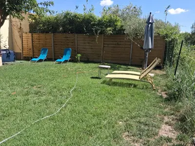 two chairs and an umbrella in a yard at Chez Kristina in Entraigues-sur-la-Sorgue