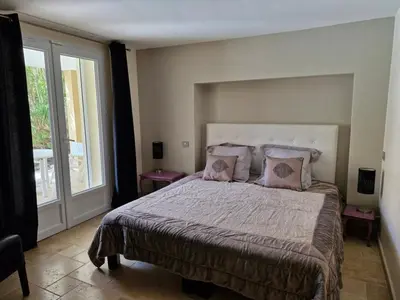 a bedroom with a large bed and a large window at La Villa Jasmin - RENDEZ-VOUS EN PROVENCE in Monteux