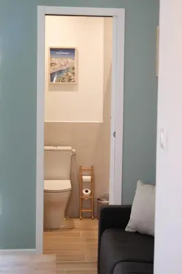 a bathroom with a toilet and a couch at Studio rénové avec belle terrasse in Aix-en-Provence