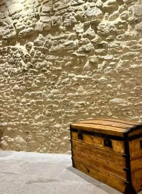 a wooden crate sitting in front of a stone wall at Mas Les Fabrys au coeur du Luberon in Bonnieux