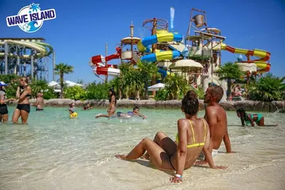 a couple sitting on the beach at a water park at Appartement climatisé au coeur de la Provence lac et parcs d'attractions 10mn Avignon in Monteux