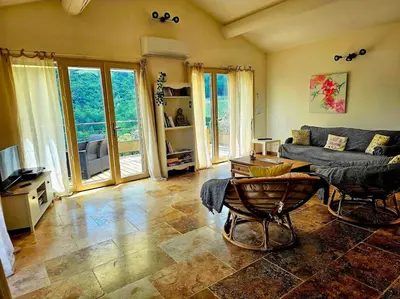 a living room with a couch and a table at La Castellane, vue imprenable sur le Luberon in Saignon