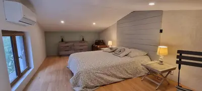 a bedroom with a bed and a dresser and a window at La Passiflore in Mazan
