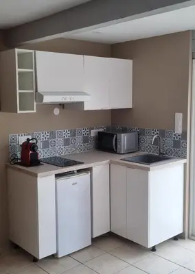 a kitchen with white cabinets and a microwave at La Passiflore in Mazan