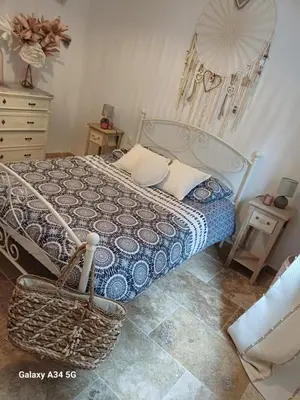 a bedroom with a bed and a basket on the floor at La Maison de Papé et Mamé in LʼIsle-sur-la-Sorgue