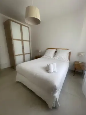 a bedroom with a large white bed with towels on it at La maison des Lilas in Aix-en-Provence