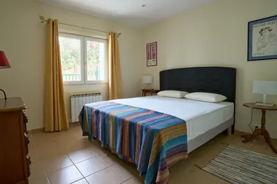 a bedroom with a bed with a colorful blanket at Maison familiale avec jacuzzi, quartier calme in Avignon