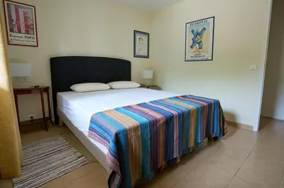 a bedroom with a bed with a colorful blanket on it at Maison familiale avec jacuzzi, quartier calme in Avignon
