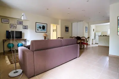 a living room with a couch and a dining room at Maison familiale avec jacuzzi, quartier calme in Avignon