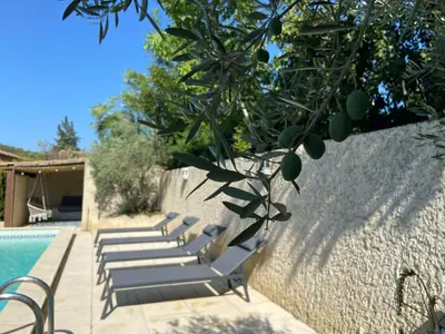 a group of lounge chairs sitting next to a pool at La maison en couleurs 3 étoiles, du calme à 10 minutes d'Avignon in Vedène