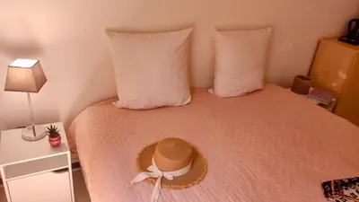a bed with a hat on top of it at Provençal-style apartment in Aix-en-Provence