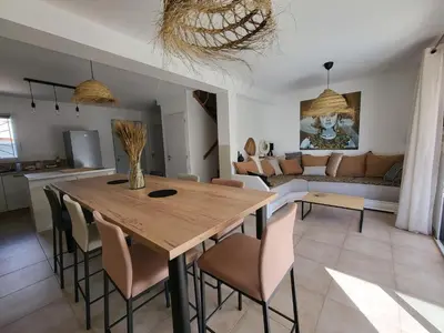 a dining room and living room with a wooden table and chairs at Pleasant detached villa with private swimming pool for 6 people in Lauris - Luberon. in Lauris