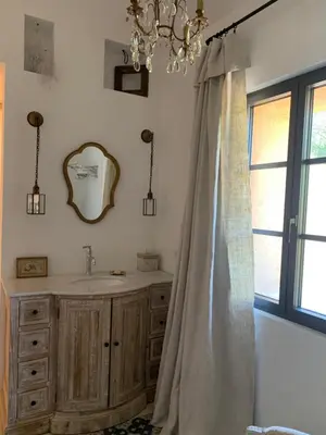 a bathroom with a sink and a mirror and a chandelier at Côté Ansouis in Ansouis