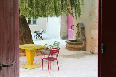 a table and chairs sitting in a courtyard with a tree at Domaine des Peyre in Robion en Luberon