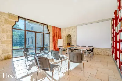 a meeting room with tables and chairs and a whiteboard at Bastide Domaine Tour Campanets in Le Puy-Sainte-Réparade