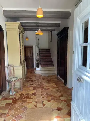 a hallway of a house with a chair and a staircase at Le Mas Carradou , Mas de Prestige en campagne in Monteux