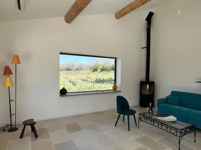 a living room with a blue couch and a window at Havre de paix sur Roussillon in Roussillon