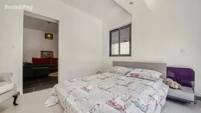 a bedroom with a large bed and a living room at Villa confortable à Morières-lès-Avignon avec jardin privé in Morières-lès-Avignon
