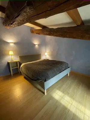a bedroom with a bed in a room with wooden ceilings at maison familiale in Saint-Trinit