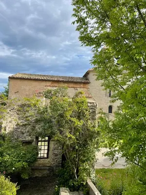 an old stone building with a tree in front of it at maison familiale in Saint-Trinit