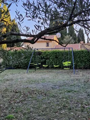 a swing set in a yard under a tree at La Villa St Antoine in LʼIsle-sur-la-Sorgue
