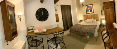 a bedroom with a bed and a clock on the wall at Le Perchoir in Mérindol