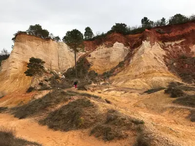 a person is walking on a dirt road in front of a mountain at Le Perchoir in Mérindol