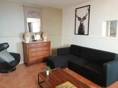 a living room with a black couch and a dresser at Le Perchoir in Mérindol
