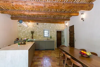a kitchen and dining room with a wooden ceiling at Mas authentique à Eygalières in Eygalières