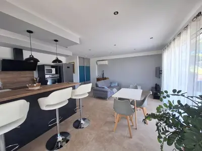 a kitchen and living room with a table and chairs at Gîte l'olivier in Sainte-Tulle