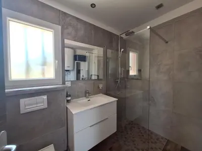 a bathroom with a sink and a glass shower at Gîte l'olivier in Sainte-Tulle