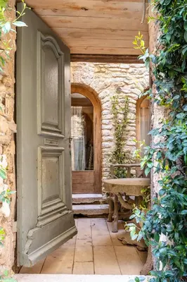 an entrance to a house with a door and a bench at L'unique in Goult