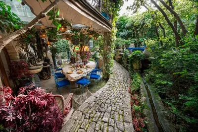a patio with a table and chairs and plants at L'unique in Goult