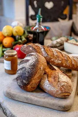 two loaves of bread sitting on a cutting board at L'unique in Goult