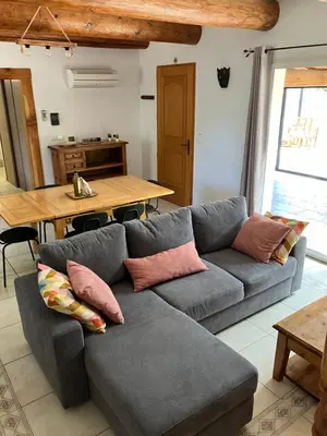 a living room with a couch and a table at Mazet des Cèdres au pied de la colline in Lagnes