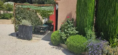 a garden with a red door and some plants at Appartement à La Bastidonne in La Bastidonne