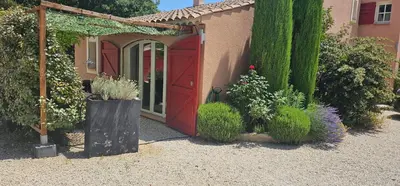 a garden with a red door and some plants at Appartement à La Bastidonne in La Bastidonne