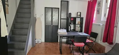 a room with a table and chairs and a staircase at Appartement à La Bastidonne in La Bastidonne