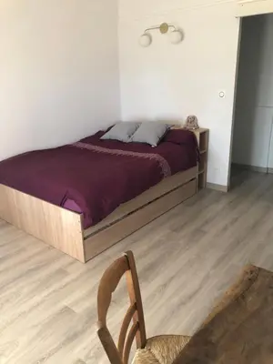 a bedroom with a bed and a wooden chair at La Respelido studio ds maison campagne in Cabannes
