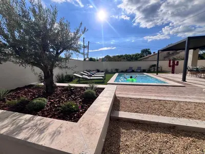 a backyard with a swimming pool and a tree at Oustau di Gaffo in LʼIsle-sur-la-Sorgue