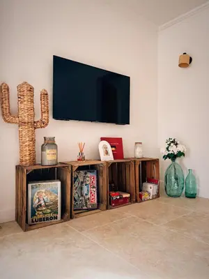 a living room with a flat screen tv on a wall at Oustau di Gaffo in LʼIsle-sur-la-Sorgue
