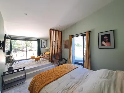 a bedroom with a large bed and a large window at La Pinède de Venelles Jacuzzi privatif in Venelles
