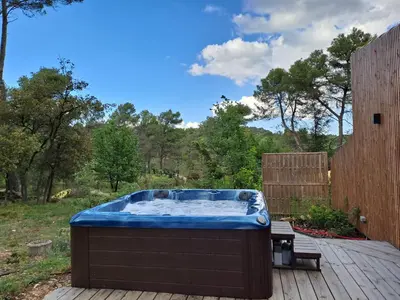 a hot tub sitting on top of a wooden deck at La Pinède de Venelles Jacuzzi privatif in Venelles