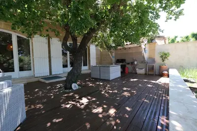 a patio with a tree in the shade at Charming Provencal Mas with pool by Taillades, close to Cavaillon in the Luberon, sleeps 6. in Les Taillades