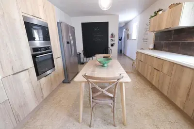 a kitchen with a wooden table and a chair in it at Charming Provencal Mas with pool by Taillades, close to Cavaillon in the Luberon, sleeps 6. in Les Taillades