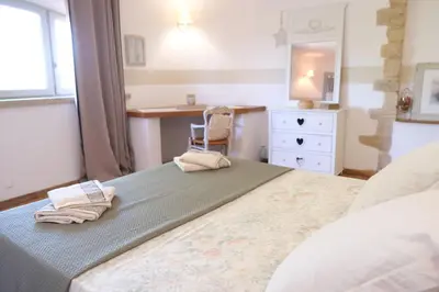 a bedroom with a bed with a desk and a chair at Charming Provencal Mas with pool by Taillades, close to Cavaillon in the Luberon, sleeps 6. in Les Taillades