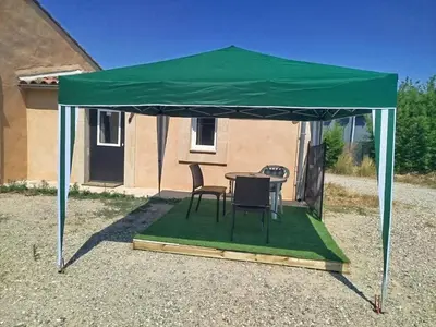 a tent with a table and chairs in a yard at Au Petit Luberon in Cheval-Blanc